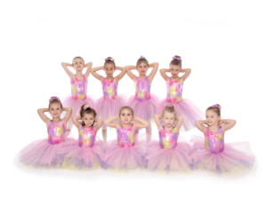 Children in ballet attire smiling and posing at a top Toronto dance school, ready for their performance